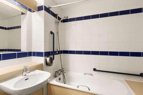 a bathroom with a sink and a tub and a shower at Days Inn Sutton Scotney South in Sutton Scotney