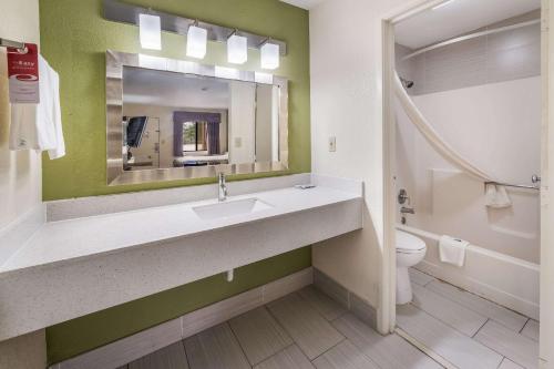 a bathroom with a sink and a toilet and a mirror at Econo Lodge Atlanta Airport East in Forest Park