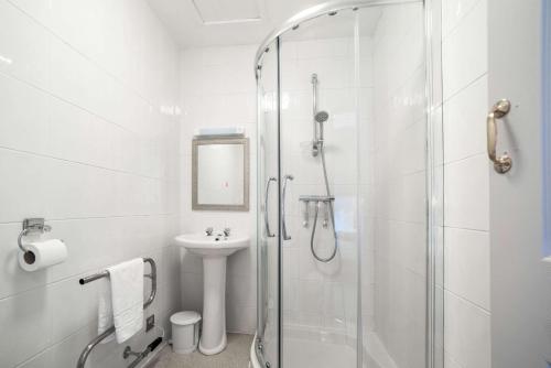 a white bathroom with a shower and a sink at Comfort Inn Blackpool Gresham in Blackpool