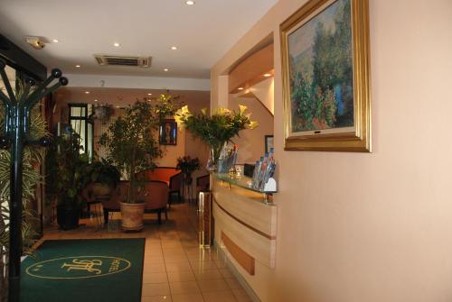 a lobby with a bar with plants and a rug at Hôtel Transcontinental in Paris