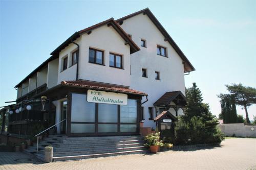 ein großes weißes Gebäude mit einem Schild drauf in der Unterkunft Hotel Waldschlösschen in Dankmarshausen