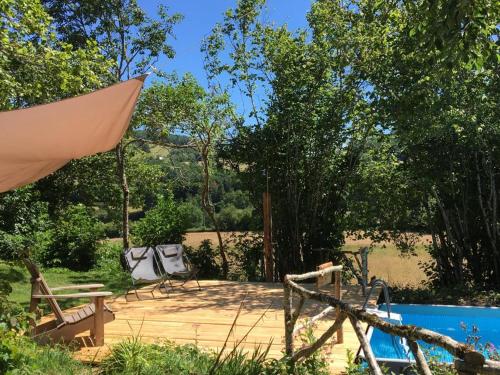 un patio avec des chaises et un parasol à côté d'une piscine dans l'établissement Les Bouaux, Briant, à Cussy-en-Morvan