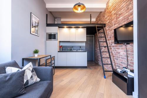 un salon avec un canapé et un mur de briques dans l'établissement 10 SEGURANE - Magnifique Studio Mezzanine - Port de Nice, à Nice