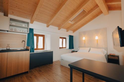 a bedroom with a bed and a kitchen with a sink at Crocevia - Locanda carsica contemporanea in Trieste