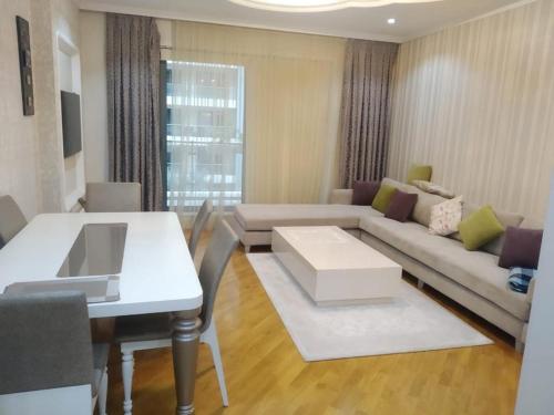 een woonkamer met een bank en een tafel bij Abmasador Apartment in Baku