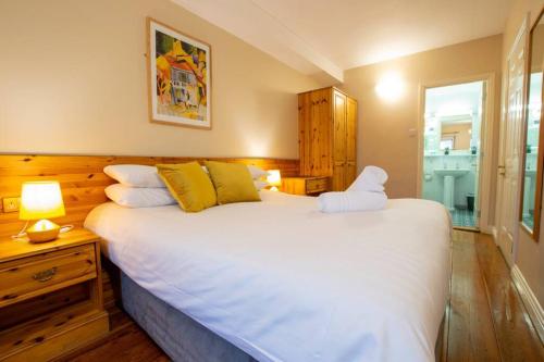 - une chambre dotée d'un grand lit blanc avec un animal rembourré dans l'établissement 310 - The Carrowbeg at The Harbour Mills by Shortstays, à Westport