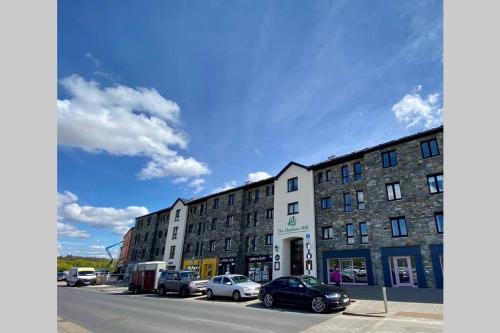 a row of buildings on a street with parked cars at 310 - The Carrowbeg at The Harbour Mills by Shortstays in Westport