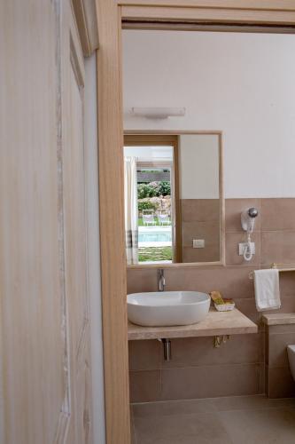 a bathroom with a sink and a mirror at La Corte Di Pulicinu in Baja Sardinia