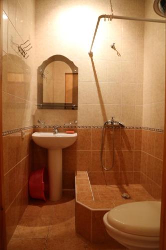 a bathroom with a sink and a toilet and a mirror at Гостевой дом in Gagra