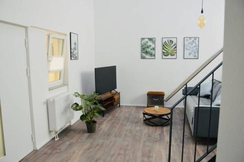 a living room with a staircase and a room with a table at Ganze Wohnung - schönes und helles Loft in Kreuzau in Kreuzau