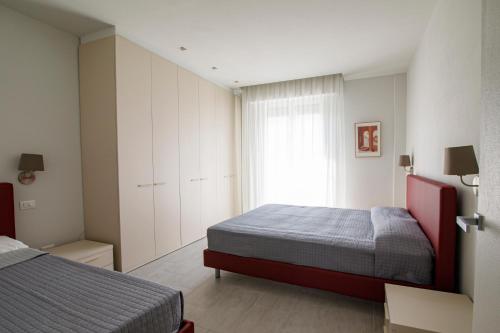 een kleine slaapkamer met 2 bedden en een raam bij Casa Plauto in Bellaria-Igea Marina