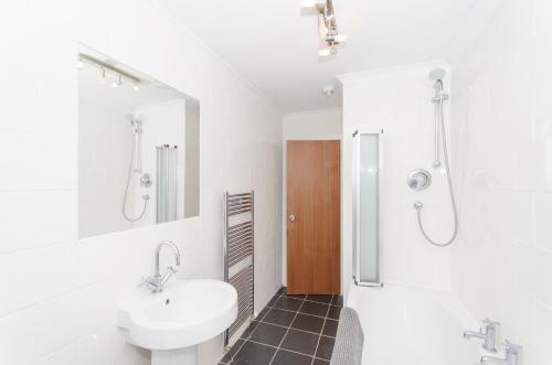 a white bathroom with a sink and a shower at Aberdeen Quiet City Apartment, Ferryhill in Aberdeen