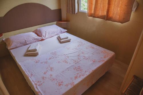 a bedroom with a bed with two towels on it at Mobile Homes Bilice in Bilice