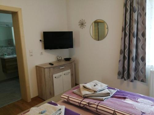 a bedroom with a bed and a tv on the wall at Wohlfühlhof Bachzelt in Weitersfeld