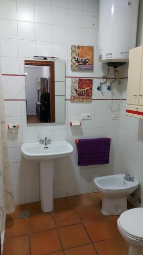 a bathroom with a sink and a toilet and a mirror at Casa del Poniente Playa y Terraza in Lepe
