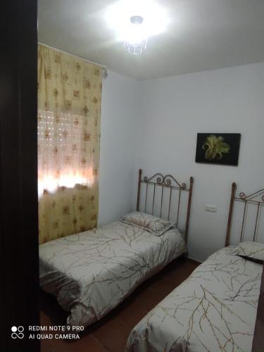 a bedroom with two beds and a window in it at Casa del Poniente Playa y Terraza in Lepe