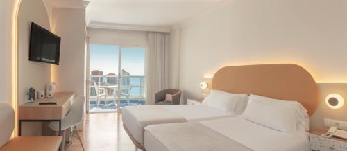 
a hotel room with a bed and a tv at Hotel RH Victoria & Spa in Benidorm
