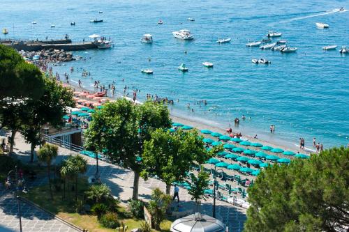 a beach with umbrellas and people in the water at Hotel Panorama in Maiori
