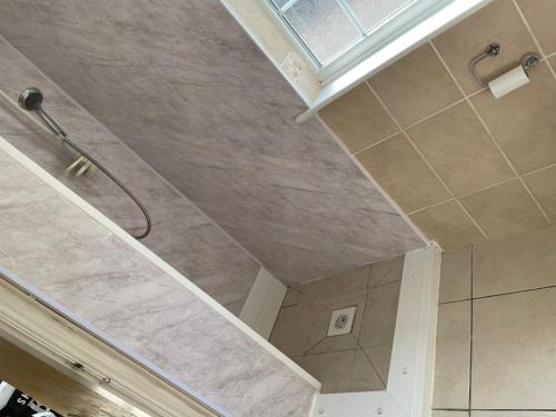 La salle de bains est pourvue d'une douche et d'un plafond. dans l'établissement Sweetpea Cottage in Louth, à Louth