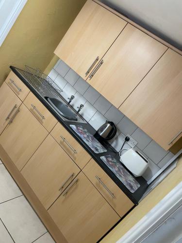 a kitchen with a sink and wooden cabinets at Rain Hill Cottage in Louth in Louth