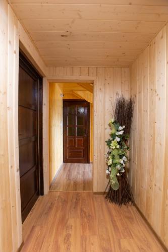 a hallway with wooden walls and a vase of flowers at U Haliny in Biały Dunajec
