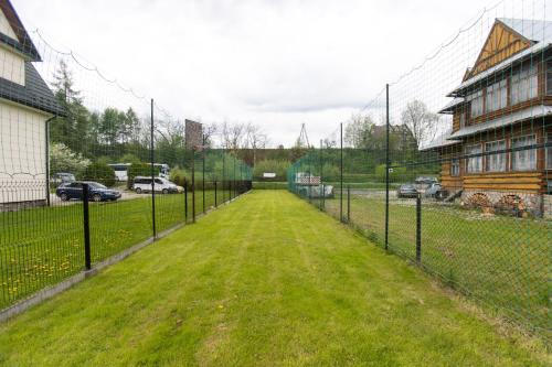 a chain link fence with a field of grass at U Haliny in Biały Dunajec
