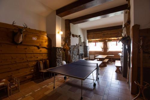 uma mesa de pingue-pongue num quarto com paredes de madeira em U Haliny em Biały Dunajec