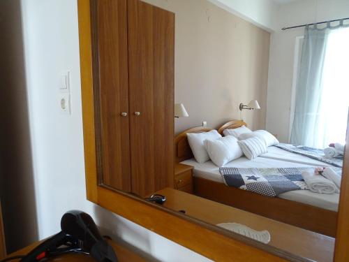 a bedroom with a mirror and a bed with white pillows at Stella Studios in Argasi