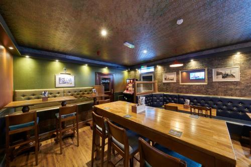 un bar con mesas de madera y sillas en un restaurante en Tailrace Inn en Kinlochleven