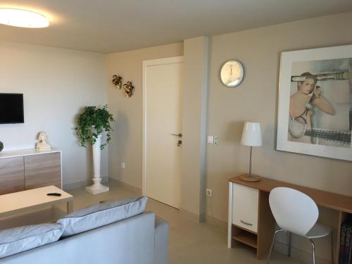 a living room with a couch and a clock on the wall at Very beautiful modern 2-Bed Apartment in Javea in Jávea