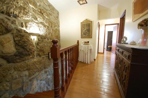 a hallway with a stone wall and a staircase with a table at Casa da Ramada - Water SPA Tank with running natural spring water - by Bedzy in Braga