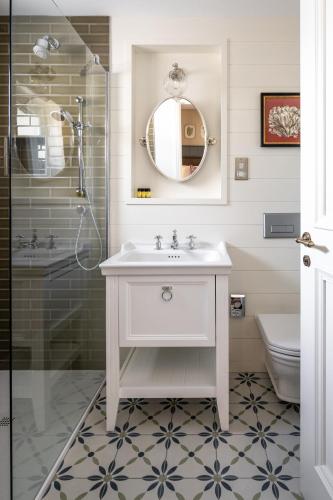 a white bathroom with a sink and a shower at The Cuan Boutique Hotel in Strangford
