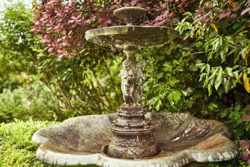 a statue of a birdbath sitting in a garden at Relais Bernard Loiseau in Saulieu