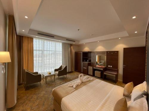 a hotel room with a large bed and a desk at درة العروس للوحدات السكنية المفروشة in Jeddah