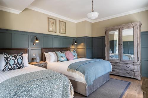 a bedroom with two beds and a mirror at The Cuan Boutique Hotel in Strangford