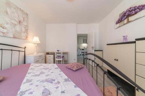 a bedroom with a bed with a purple blanket at Strawberry in Split