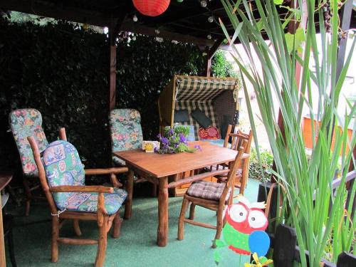 a wooden table and two chairs and a table with flowers at Zimmervermietung Leuba in Ostritz