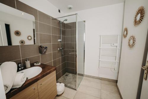 La salle de bains est pourvue d'un lavabo et d'une douche en verre. dans l'établissement Charmant appartement 4 étoiles Bella Vita Zen, à Aix-les-Bains