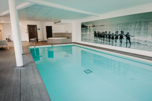 een zwembad met een schilderij van een voetbalteam bij Charmant appartement 4 étoiles Bella Vita Zen in Aix-les-Bains