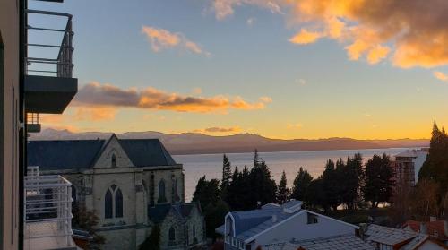 Una vista de una iglesia y el océano al atardecer. en Bariloche Modern Apartment, en San Carlos de Bariloche