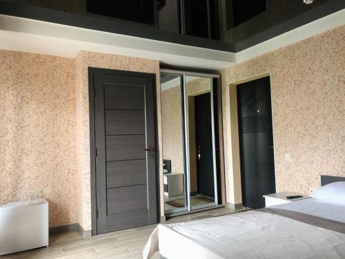 a bedroom with a bed and a door with windows at Bloom Hotel in Kharkiv