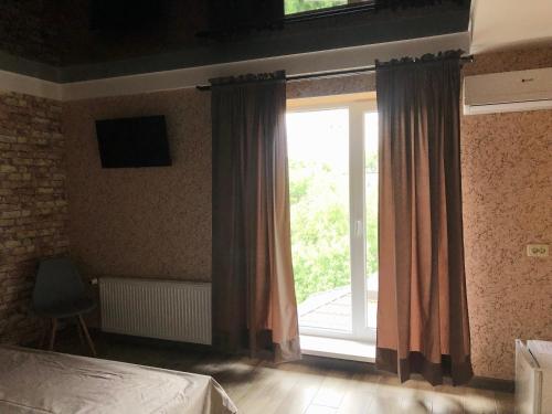 a bedroom with a large window with a sliding glass door at Bloom Hotel in Kharkiv