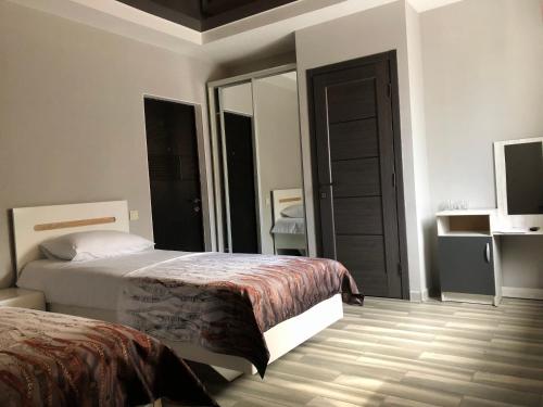 a bedroom with two beds and a large mirror at Bloom Hotel in Kharkiv