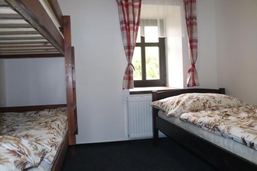 a bedroom with two bunk beds and a window at apartmány Kynast in Albrechtice v Jizerských horách