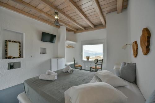 a white bedroom with a bed and a table at Ftelia View in Ftelia