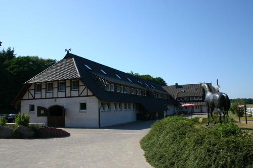 un bâtiment avec une statue de cheval devant lui dans l'établissement STöRTEBEKER APPARTEMENTS - "STöRTEBEKER PFERDEHOF", à Ralswiek