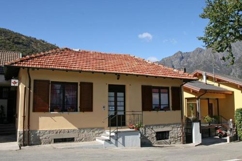 una pequeña casa amarilla con techo rojo en Cà di Twergi, en Ornavasso