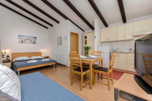 uma sala de estar com uma cama e uma sala de jantar em Apartments Ante em Vodice