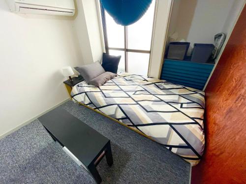 a small room with a bed and a table at WEST WOOD GUEST ROOM in Osaka