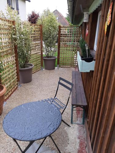 a blue table and a table and a bench on a patio at tres beau gite ,une ou deux personnes, super équipé 25m2 in Nogent-sur-Seine